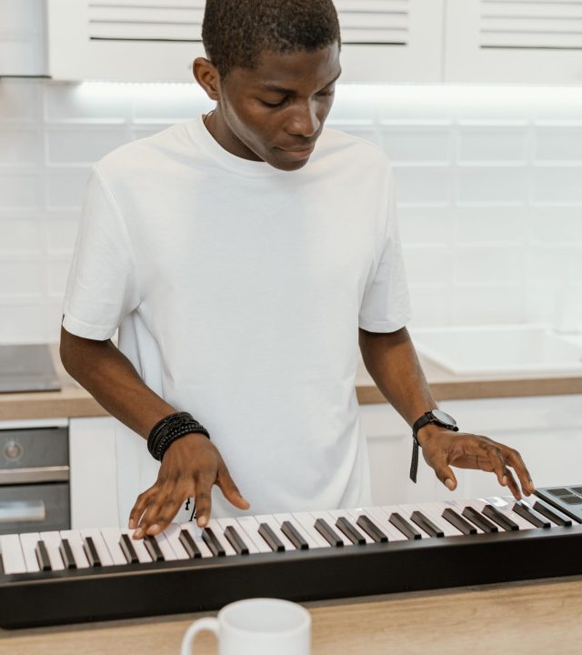 front-view-male-musician-home-playing-electric-keyboard